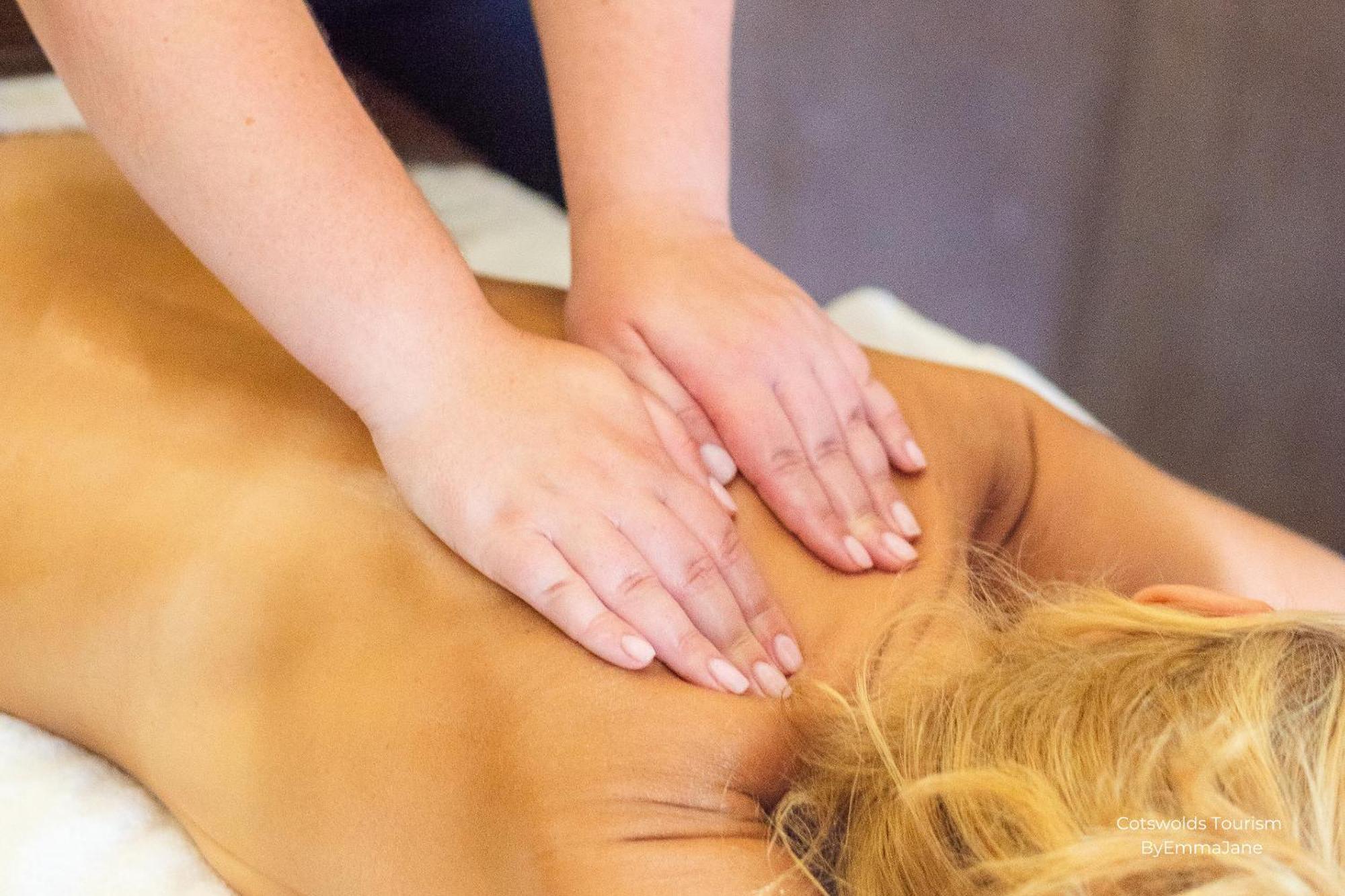 Hotel Ellenborough Park Bishop's Cleeve Esterno foto A massage therapist applying deep tissue massage to a woman's lower back